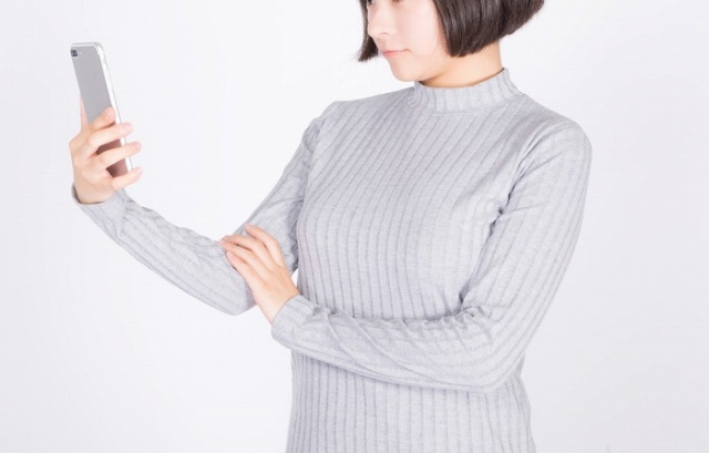 スマホをいじる女性