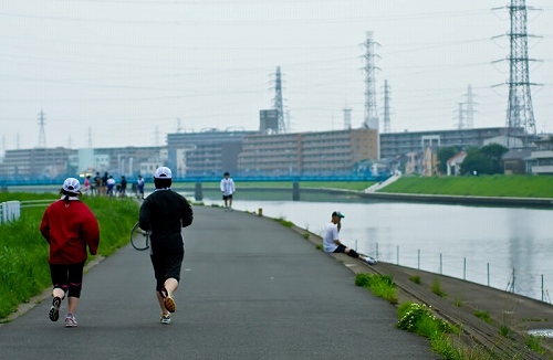 川辺で走るランナーの後ろ姿